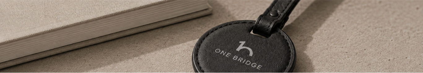 OneBridge leather keychain resting on a notebook